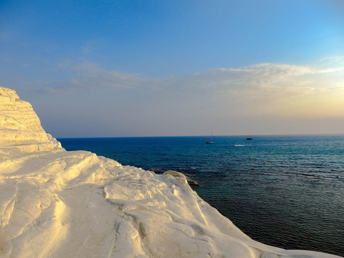 Aerial view of one of the top10 beaches in Italy with turquoise Mediterranean water, white sandy cove, and rugged coastal cliffs