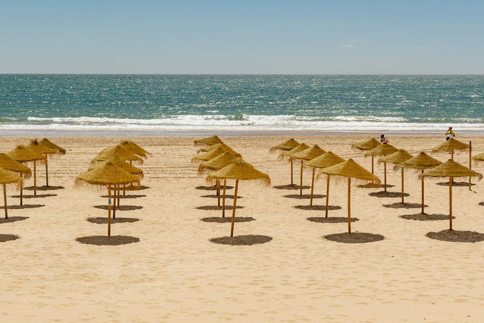 Aerial view of one of the top 10 beaches in Southern Spain with golden sand, turquoise water, and rugged coastal dunes